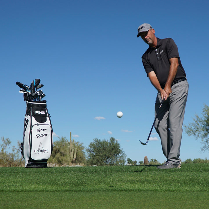 Man playing golf on a sunny day with a clear blue sky
